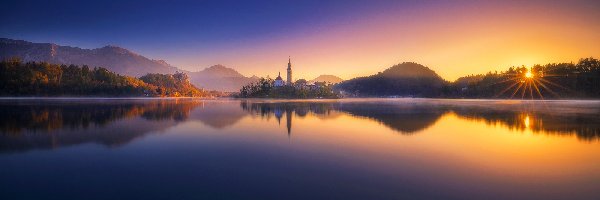 Promienie słońca, Góry Alpy Julijskie, Jezioro Bled, Wyspa Blejski Otok, Słowenia, Zachód słońca, Kościół Zwiastowania Marii Panny