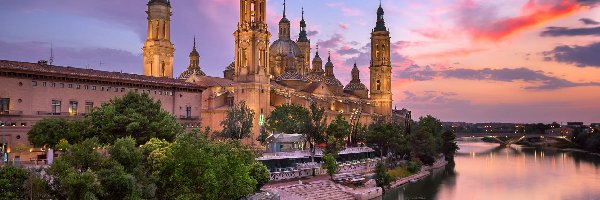 Bazylika Nuestra Senora del Pilar, Saragossa, Chmury, Bazylika katedralna Matki Bożej na Kolumnie, Rzeka Ebro, Most, Drzewa, Hiszpania, Aragonia, Zachód słońca