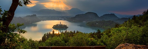 Jezioro Bled, Blejski Otok, Drzewa, Chmury, Góry Alpy Julijskie, Ławka, Zachód słońca, Słowenia